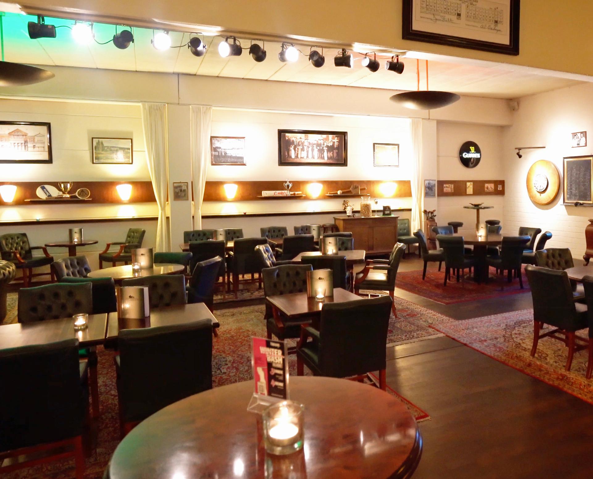 Restaurantraum mit Spot-Schiene und grünen Chesterfield-Stühlen